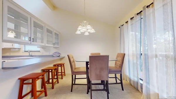 a view of a dining room with furniture and chandelier
