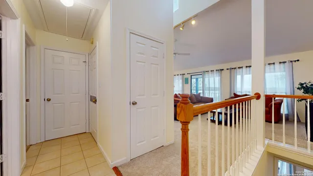 a view of a hallway with wooden staircase and door