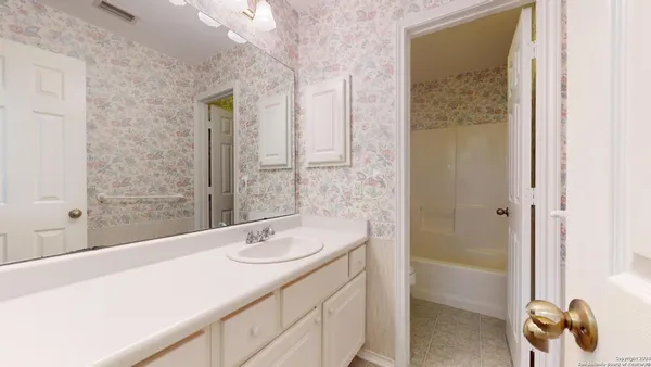 a bathroom with a tub sink and mirror