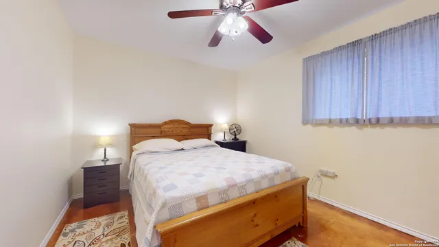 a bedroom with a bed and a chandelier fan
