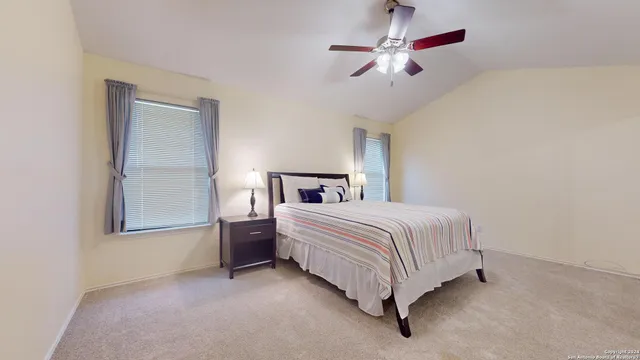 a bedroom with a bed ceiling fan and a window