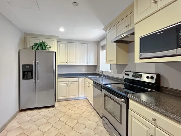 a kitchen with stainless steel appliances granite countertop a refrigerator and a stove top oven