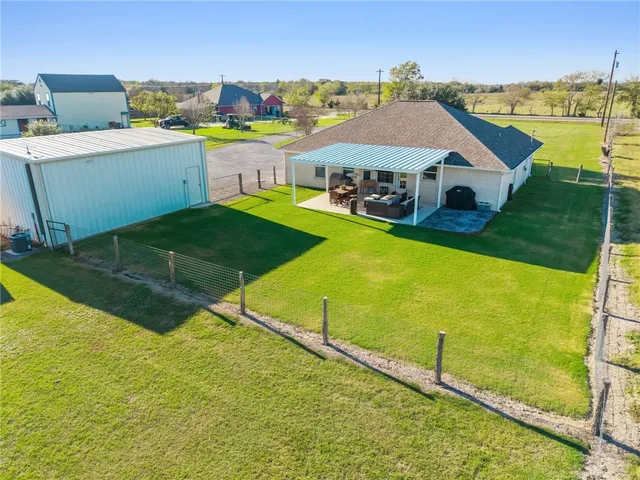 a aerial view of a house with a yard and sitting area