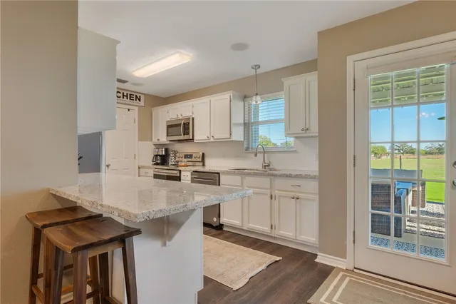 a kitchen with kitchen island granite countertop a sink cabinets and counter space