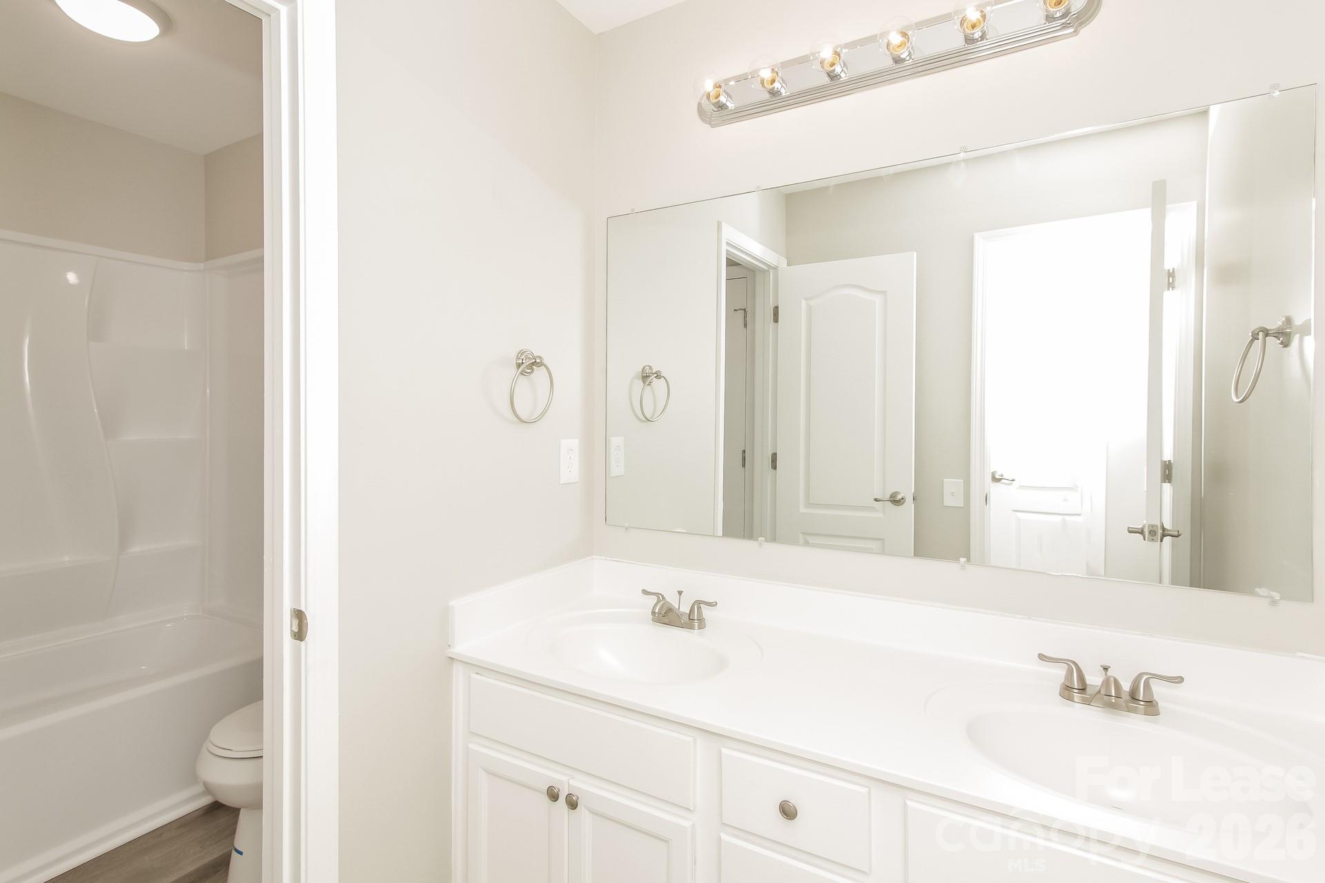 11004 Greenhead View Road Charlotte, NC 28262 - Photo 14 of 17 a bathroom with a tub sink and mirror