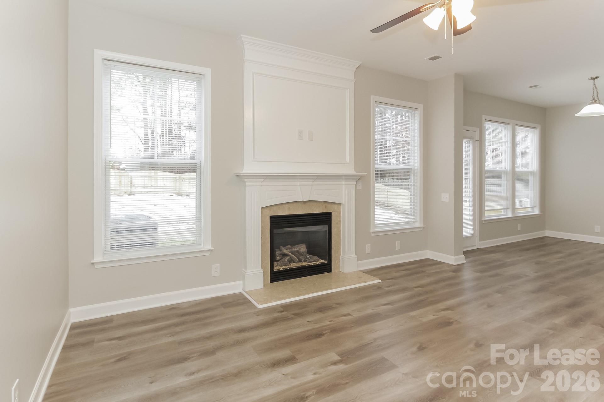 11004 Greenhead View Road Charlotte, NC 28262 - Photo 3 of 17 an empty room with wooden floor fireplace and windows