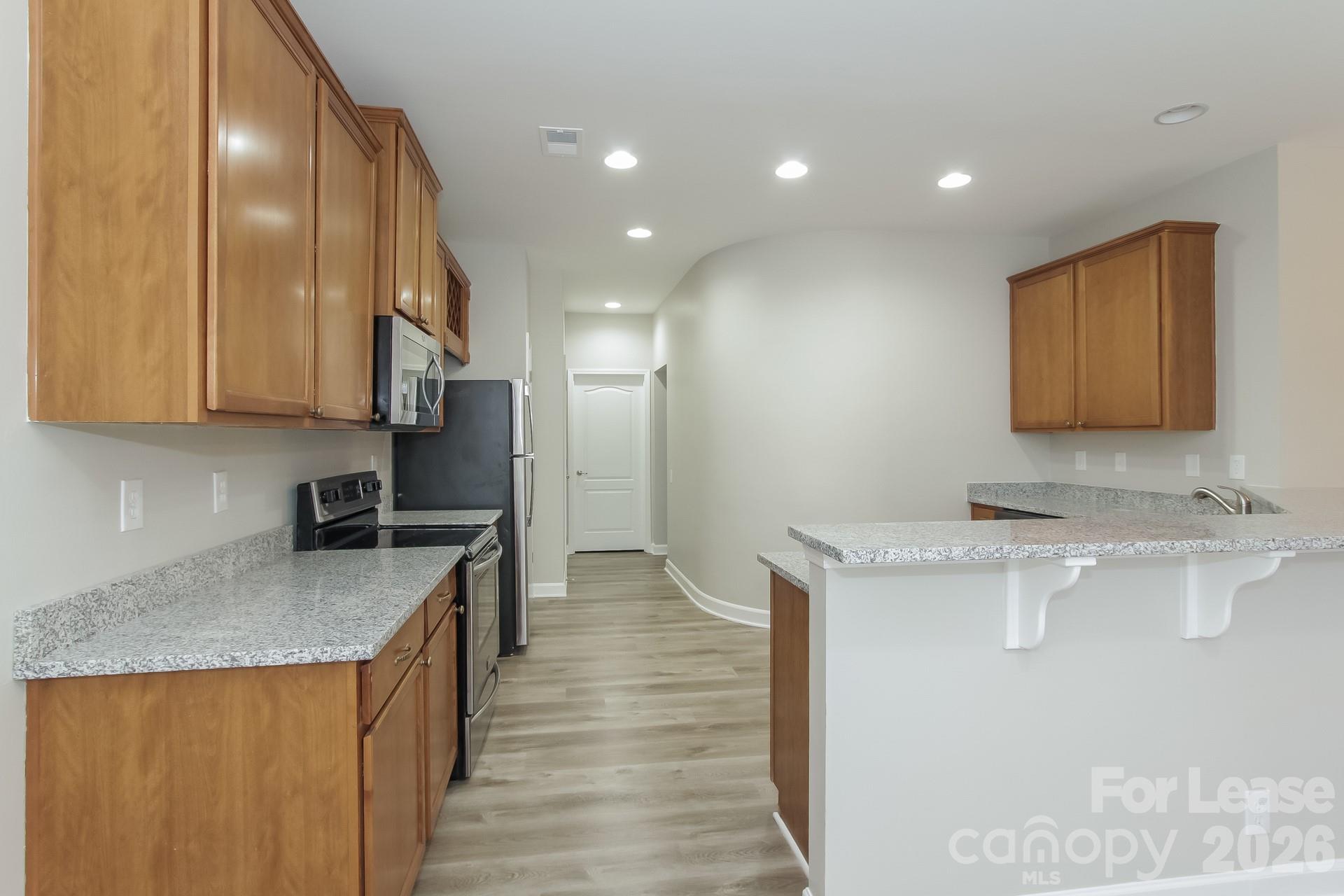 11004 Greenhead View Road Charlotte, NC 28262 - Photo 6 of 17 a kitchen with a sink stove and cabinets