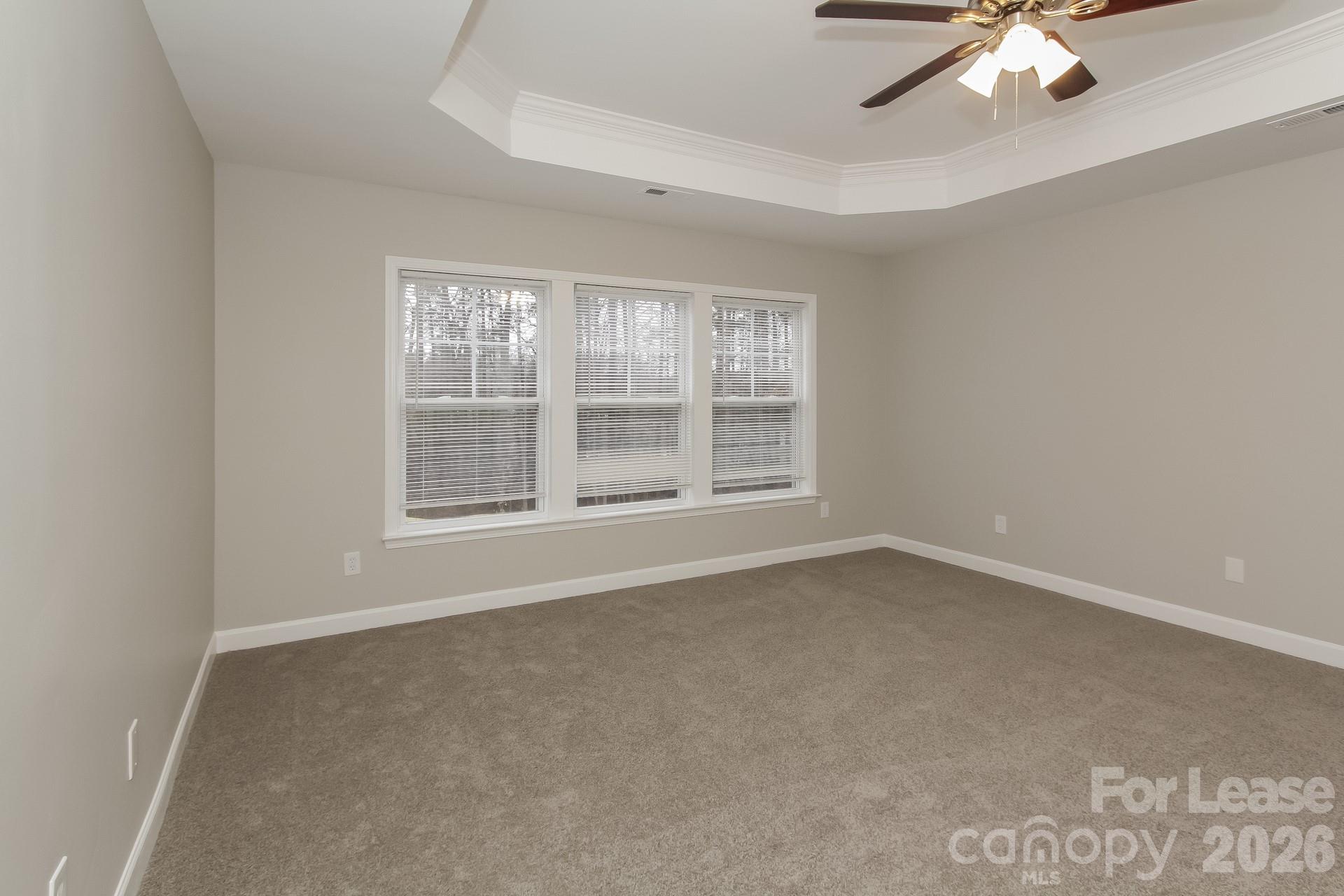 11004 Greenhead View Road Charlotte, NC 28262 - Photo 9 of 17 an empty room with a chandelier fan and windows