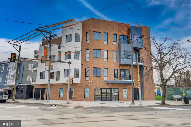 a front view of a residential apartment building with a yard