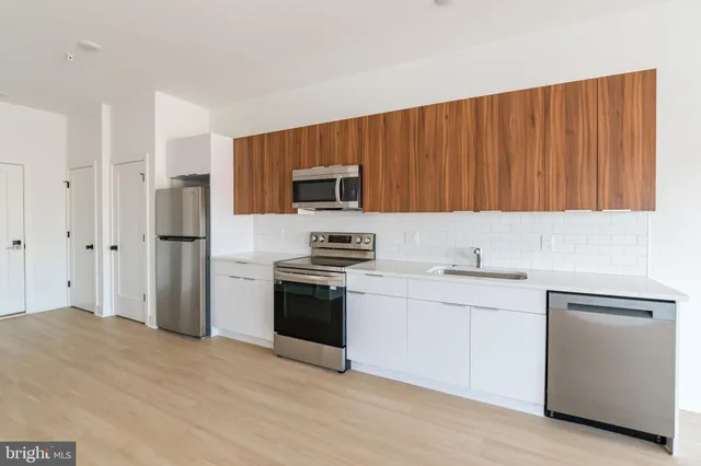 a kitchen with stainless steel appliances granite countertop a refrigerator stove and sink