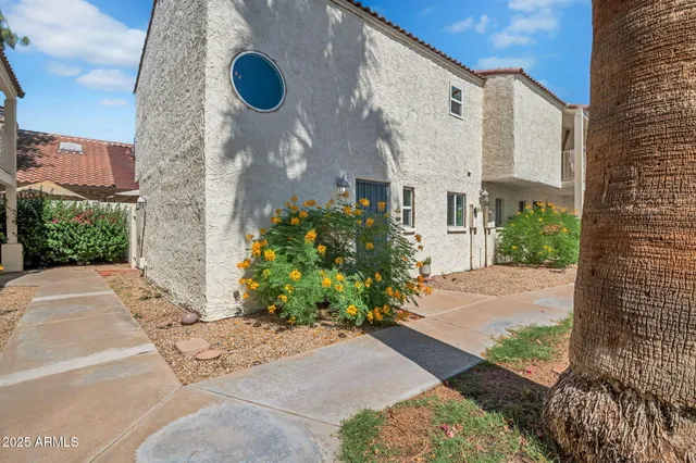 a view of a white building next to a yard