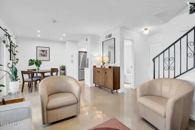 a living room with furniture a refrigerator and a dining table