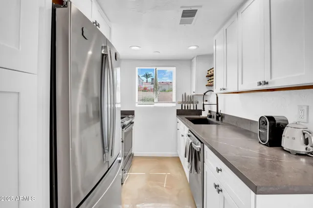 a kitchen with stainless steel appliances granite countertop a refrigerator and a sink