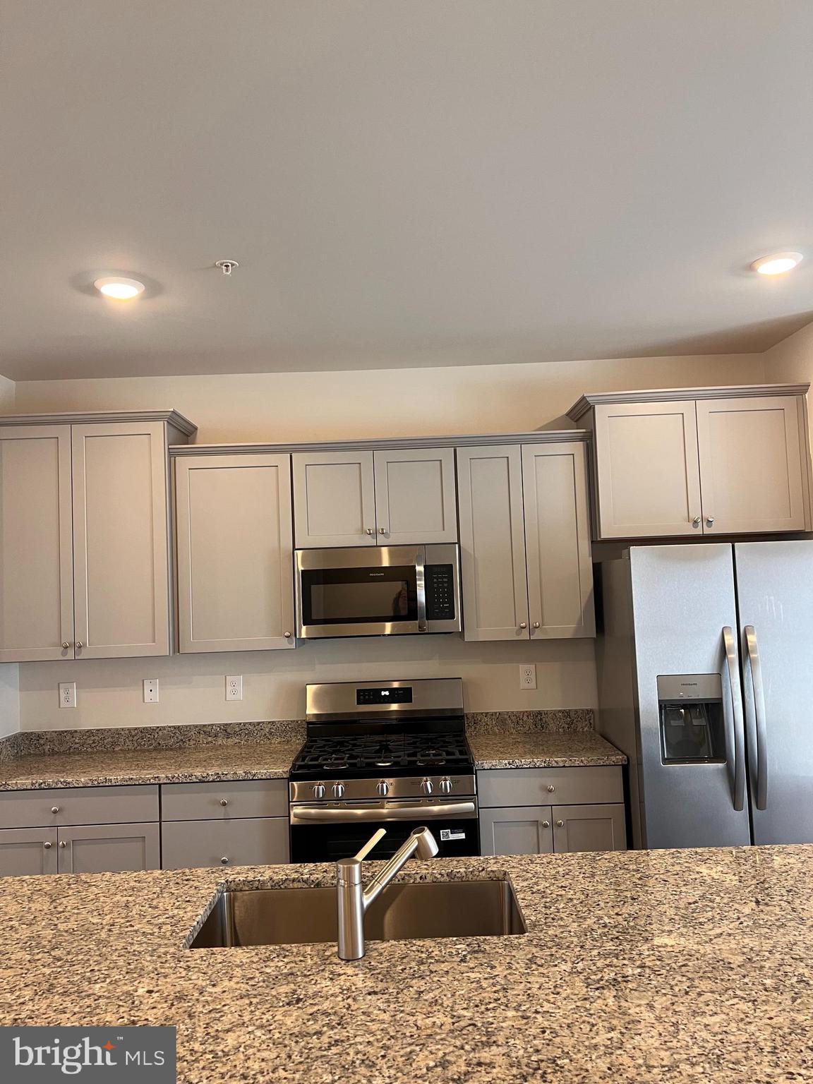 13931 Anderson Garden Road Laurel, MD 20707 - Photo 26 of 32 a kitchen with kitchen island granite countertop a stove a sink and a microwave