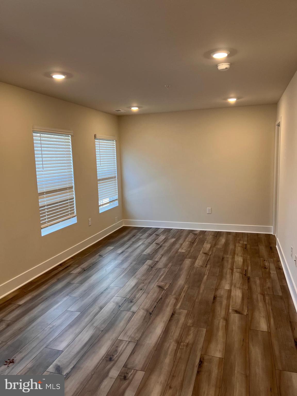 13931 Anderson Garden Road Laurel, MD 20707 - Photo 30 of 32 an empty room with wooden floor and windows