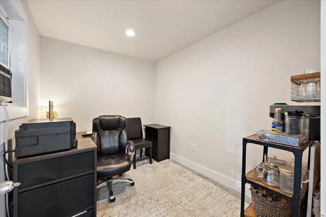 a dining hall with stainless steel appliances granite countertop a table chairs and a chandelier