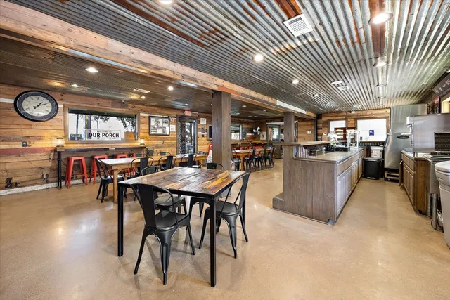 a view of a kitchen with kitchen island a large window a sink and stainless steel appliances
