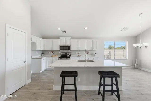 a kitchen with stainless steel appliances kitchen island granite countertop a sink and cabinets