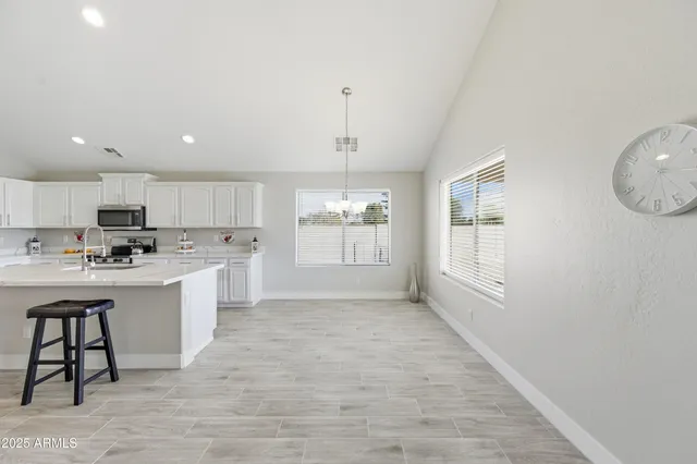 a large kitchen with kitchen island a sink stainless steel appliances and cabinets
