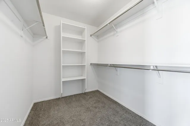 an empty room with cabinet and windows