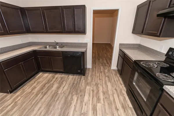 a kitchen with wooden cabinets and a stove top oven