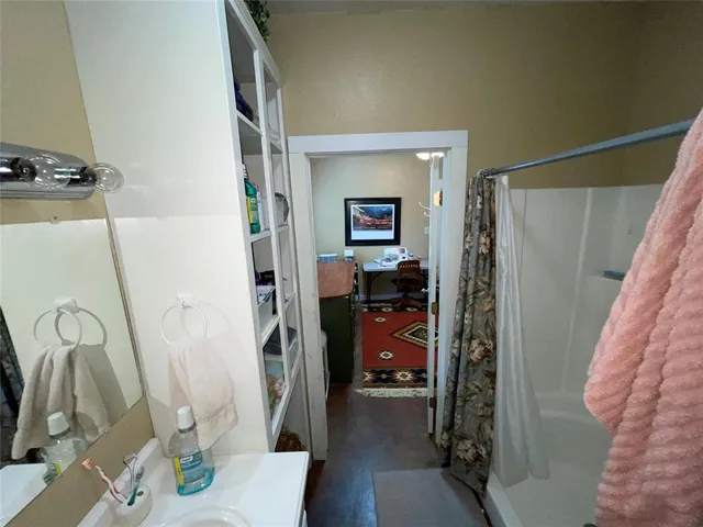 a bedroom with a bed a chandelier and dresser