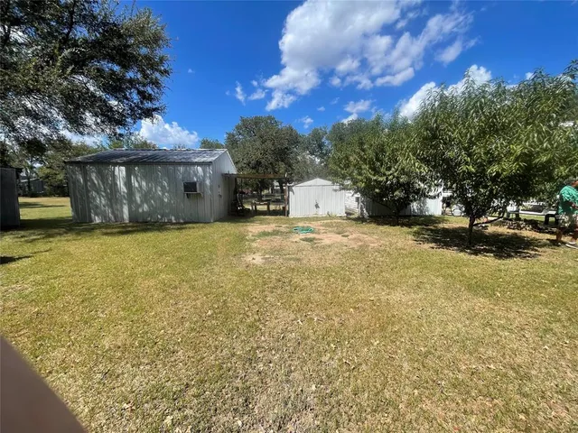 a backyard of a house with fire pit and trees