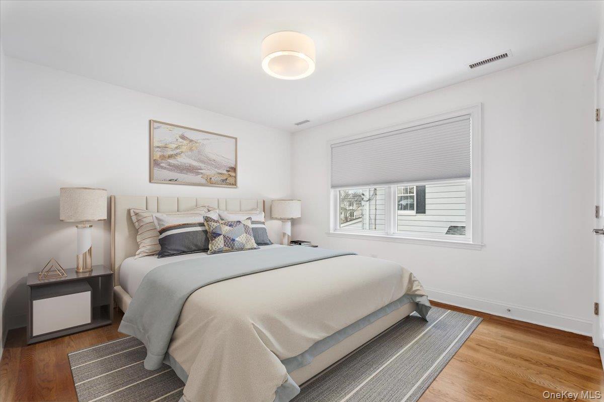 109 Lee Road Scarsdale, NY 10583 - Photo 14 of 30 a spacious bedroom with a bed and a painting on the wall