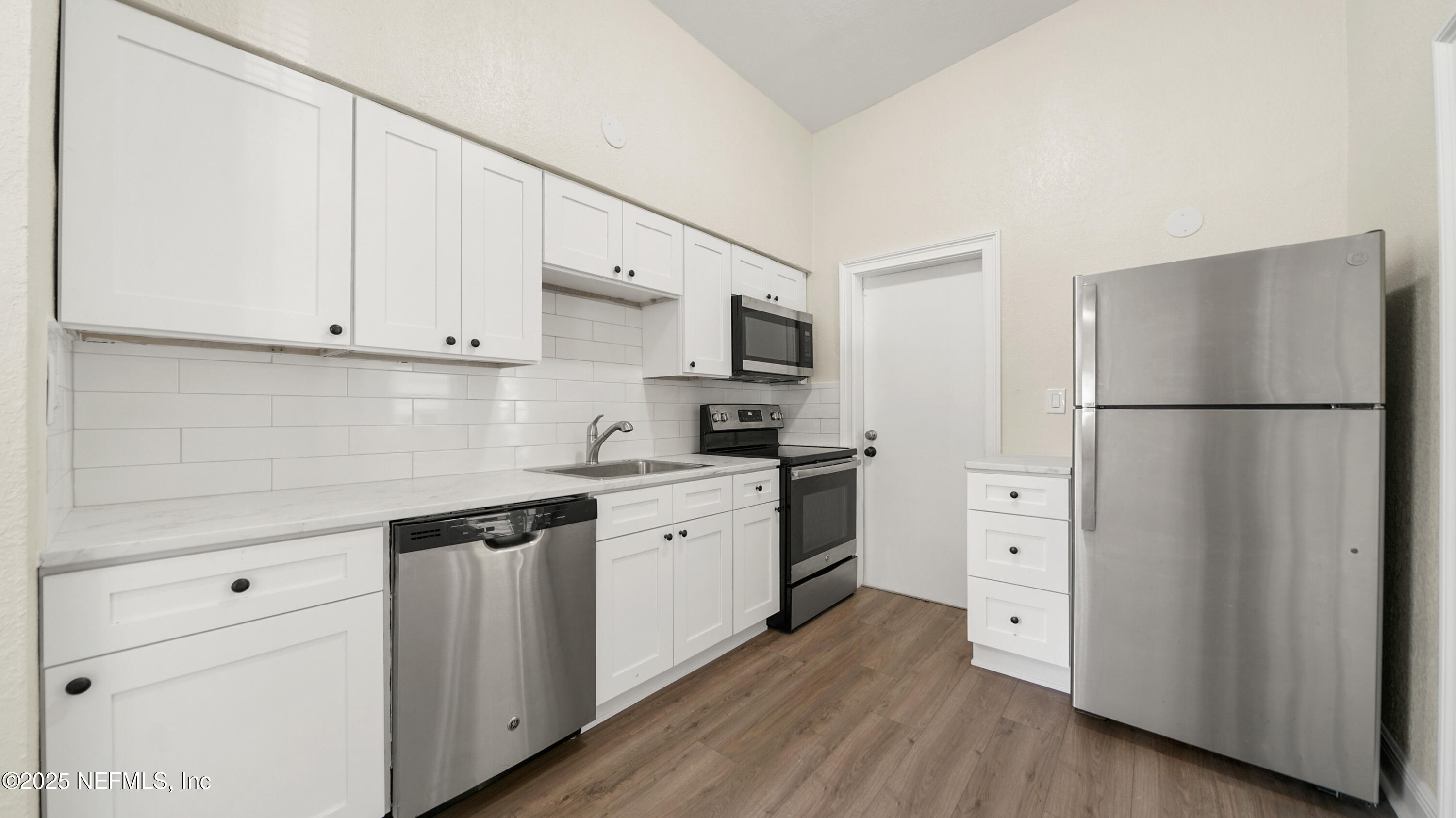 5524 Verbena Road Jacksonville, FL 32209 - Photo 3 of 17 a kitchen with stainless steel appliances a refrigerator sink and cabinets