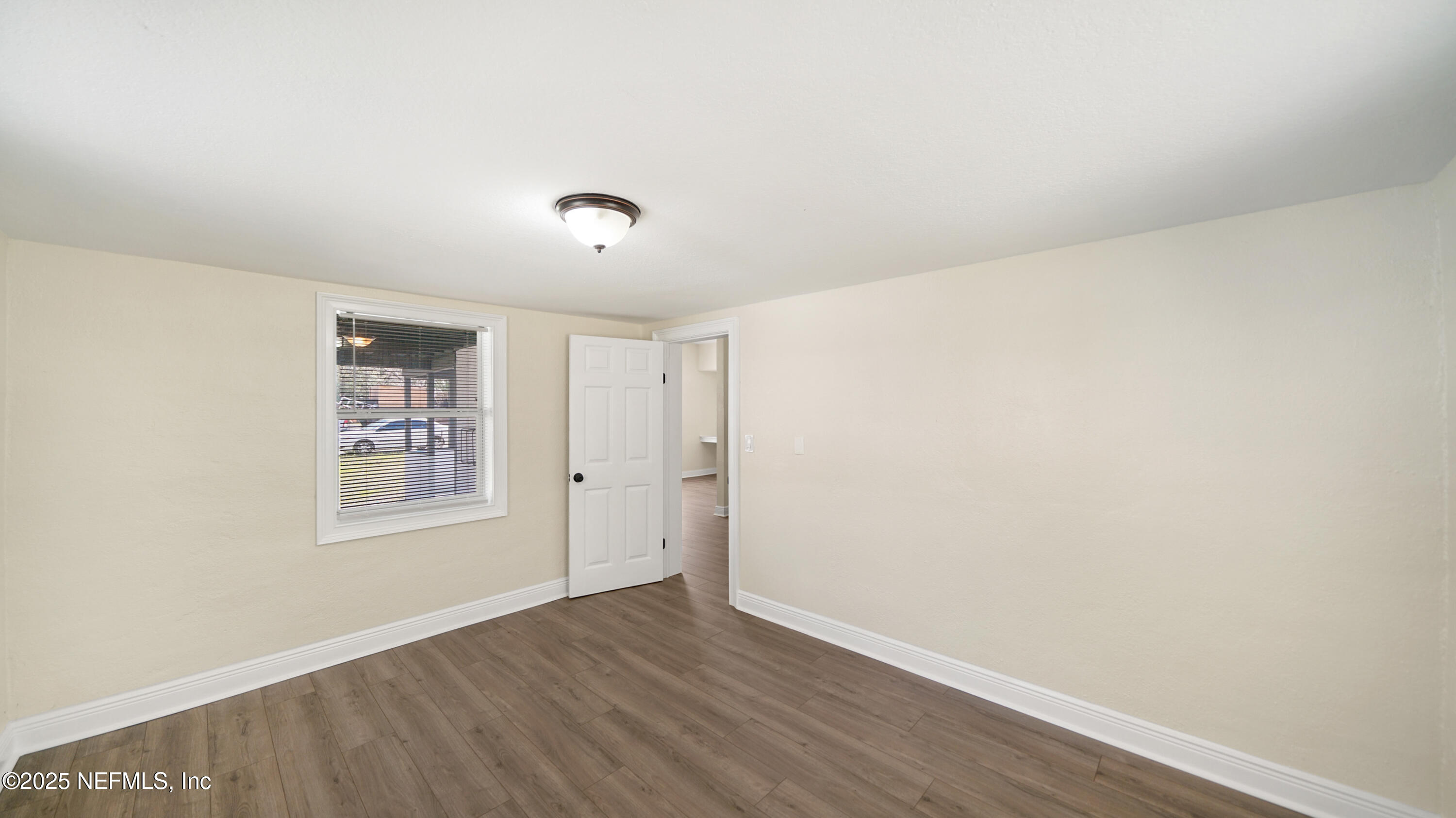 5524 Verbena Road Jacksonville, FL 32209 - Photo 8 of 17 an empty room with wooden floor and windows