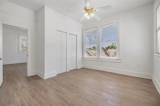 an empty room with windows and fan