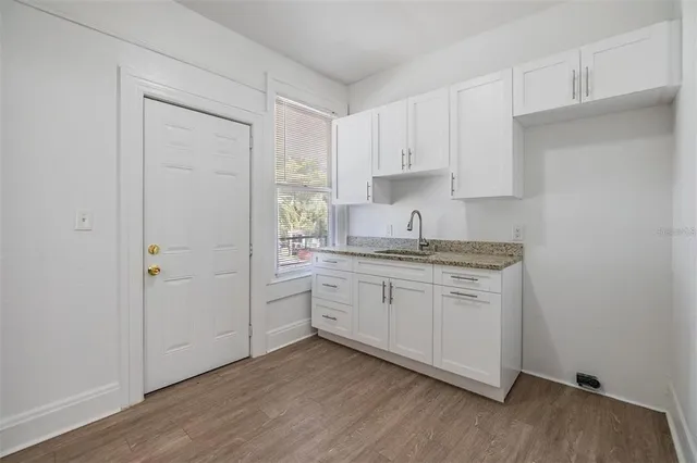 a kitchen with sink cabinets and wooden floor