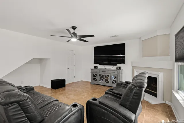 a living room with furniture a flat screen tv and a fireplace