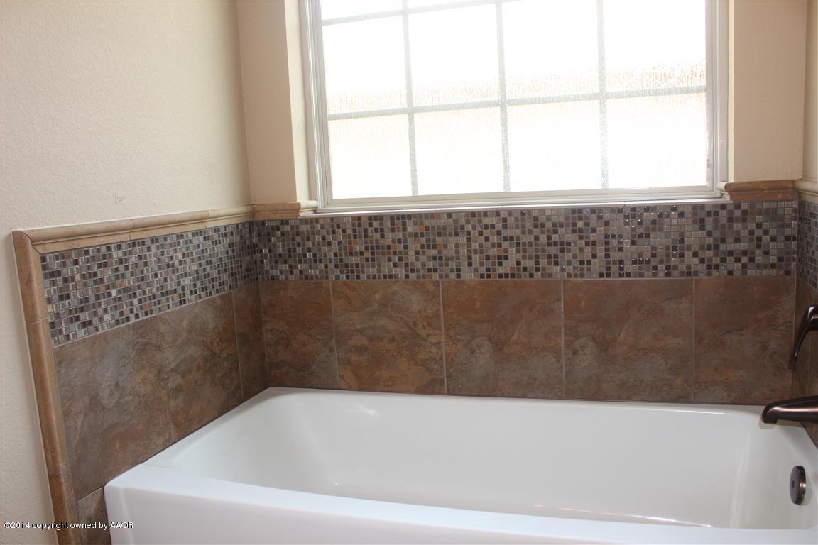 3910 Arden Road Amarillo, TX 79118 - Photo 12 of 15 a bathroom with a bathtub and window