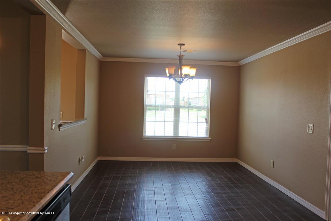 3910 Arden Road Amarillo, TX 79118 - Photo 8 of 15 an empty room with wooden floor chandelier and windows