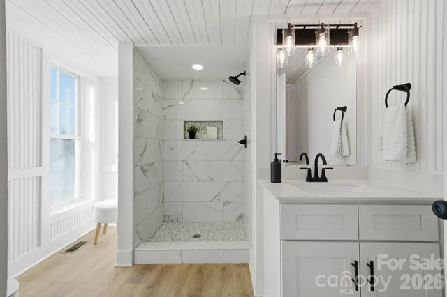 a bathroom with a sink a toilet and shower