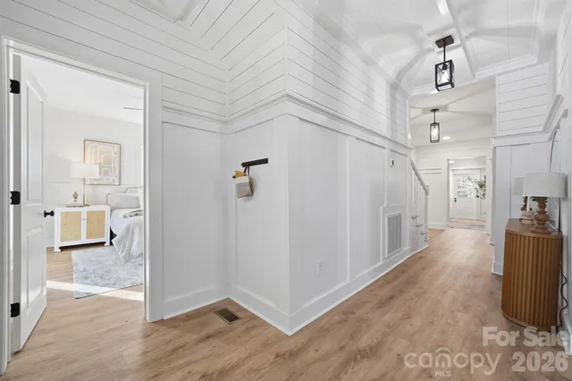 a kitchen with stainless steel appliances granite countertop a stove a refrigerator a sink dishwasher and white cabinets with wooden floor