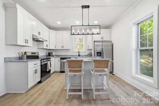 a kitchen with granite countertop a sink stainless steel appliances and cabinets