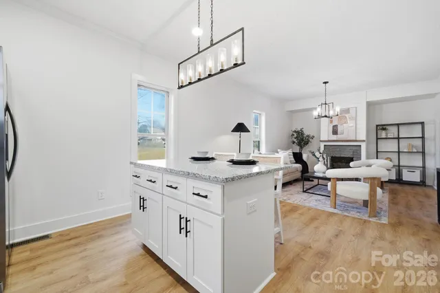 a living room with furniture a fireplace and a chandelier