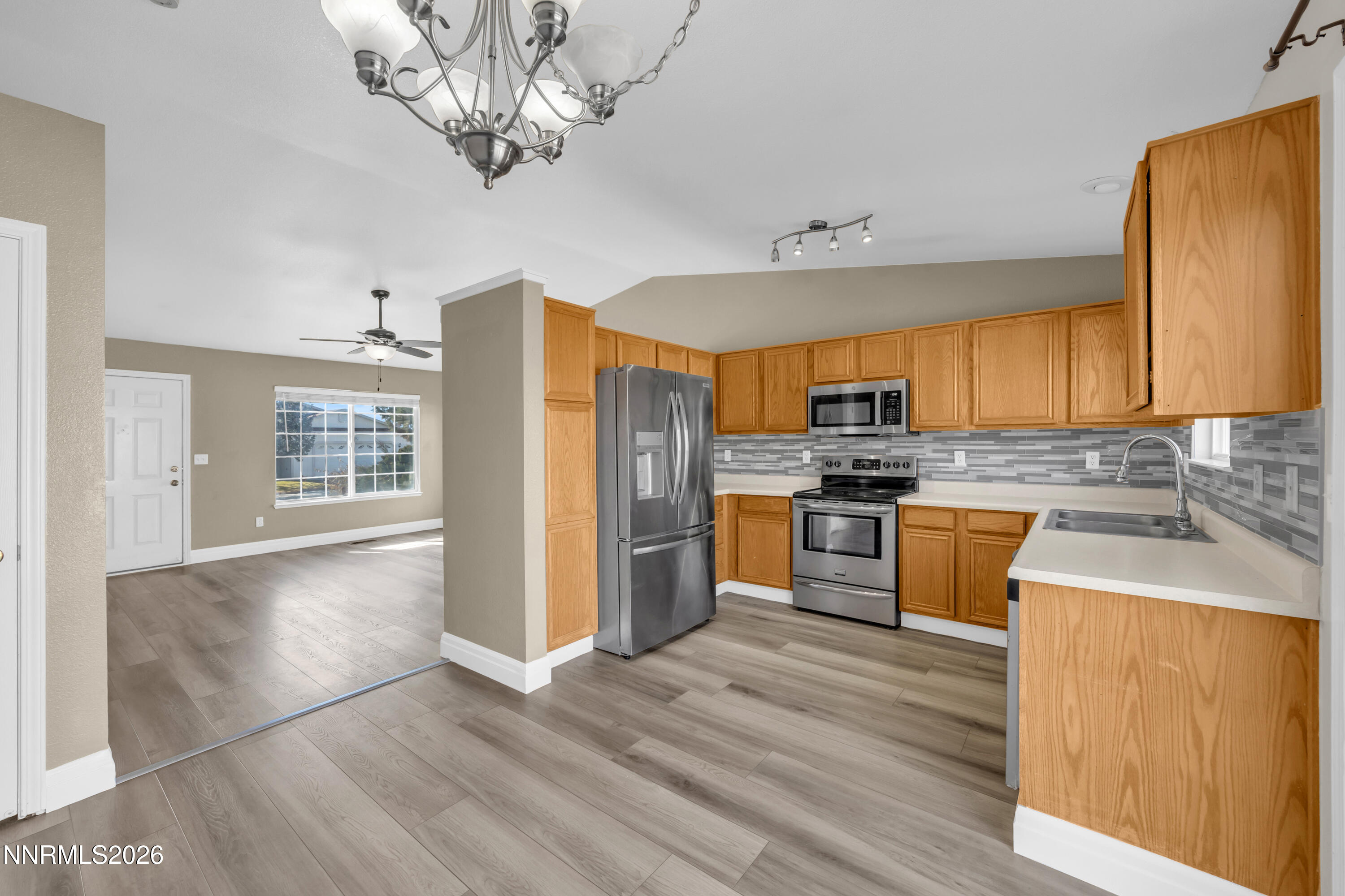 7295 Raphael Drive Sun Valley, NV 89433 - Photo 24 of 44 a kitchen with stainless steel appliances granite countertop a refrigerator a sink dishwasher a stove with wooden cabinets and floor