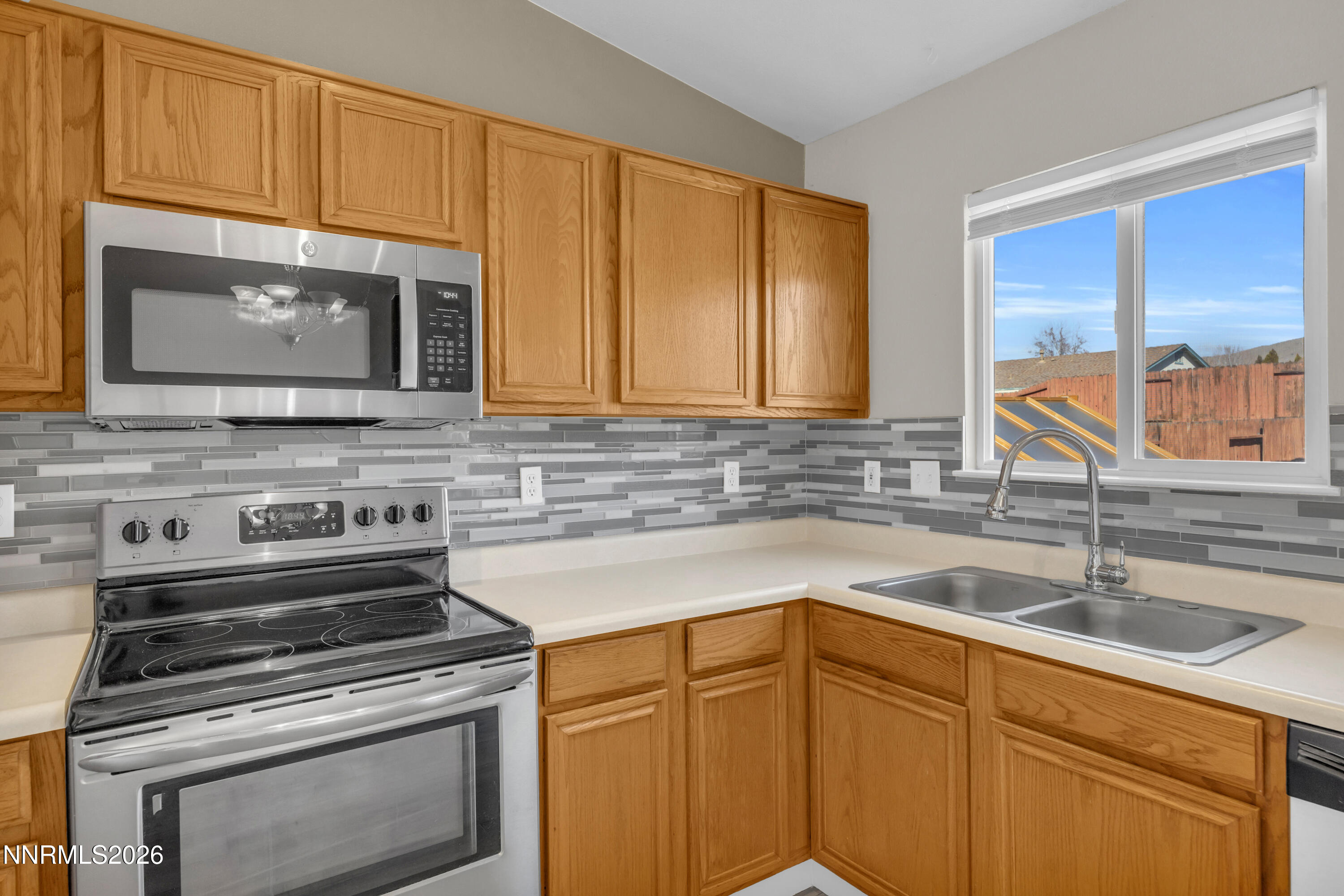 7295 Raphael Drive Sun Valley, NV 89433 - Photo 27 of 44 a kitchen with stainless steel appliances granite countertop a sink stove and microwave