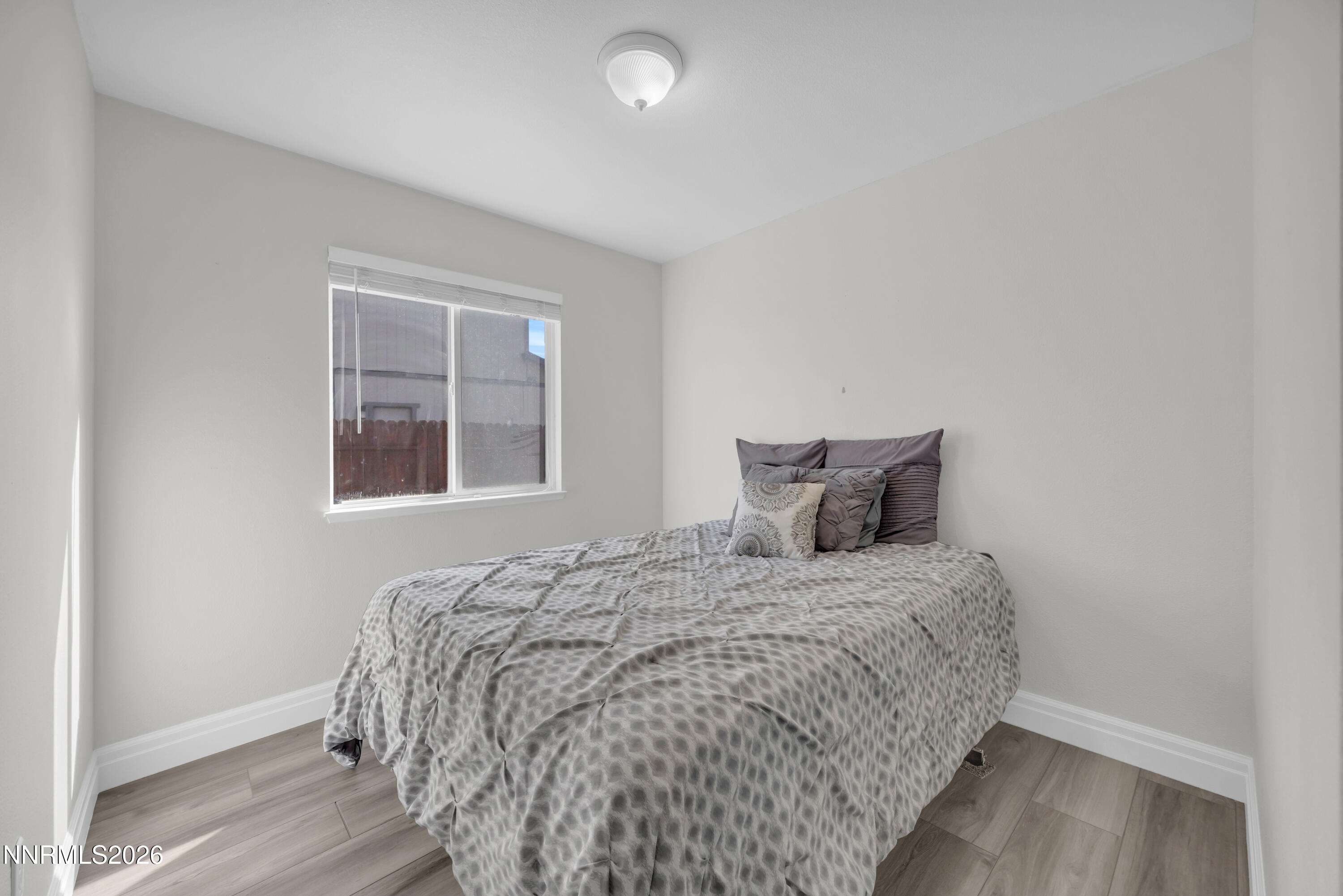 7295 Raphael Drive Sun Valley, NV 89433 - Photo 32 of 44 a large bed sitting in a bedroom next to a window and a wooden floor