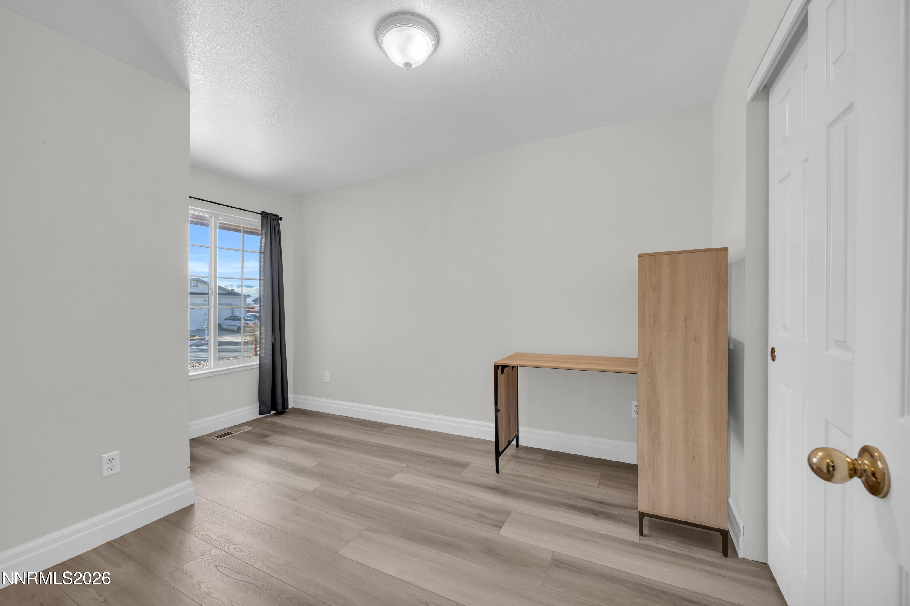 7295 Raphael Drive Sun Valley, NV 89433 - Photo 34 of 44 a view of an empty room with wooden floor and a window