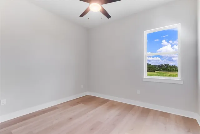 an empty room with wooden floor and window
