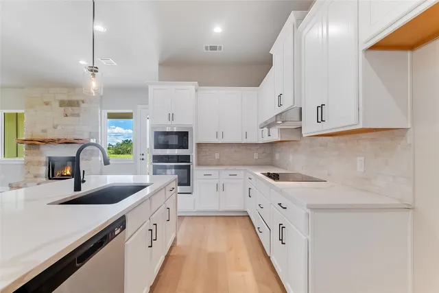 a kitchen with white cabinets and a sink
