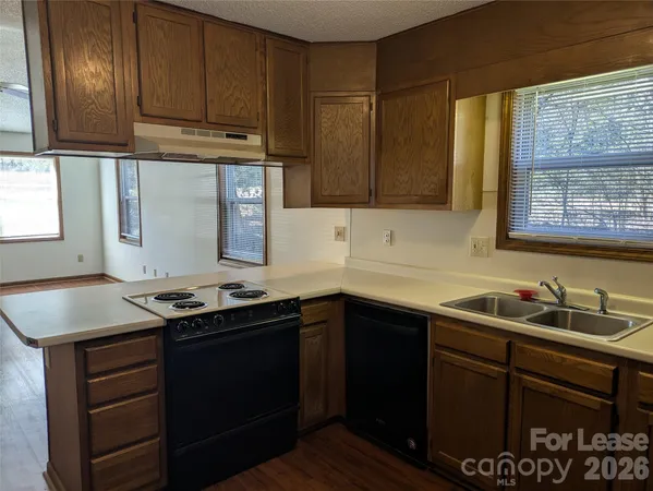 a kitchen with stainless steel appliances granite countertop a sink stove and cabinets