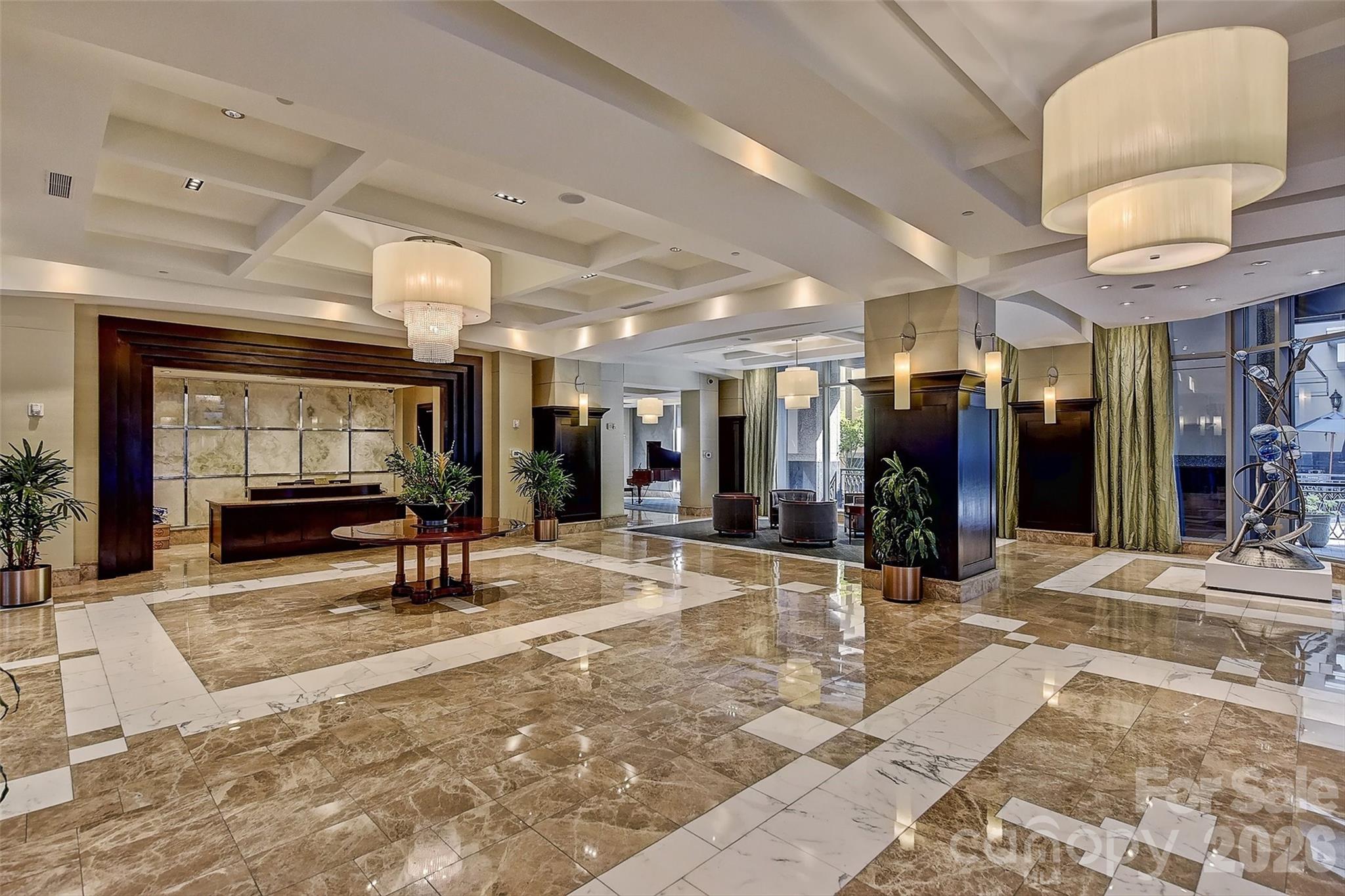 230 South Tryon Street, Unit 908 Charlotte, NC 28281 - Photo 2 of 31 a view of a lobby with a couch and a potted plant