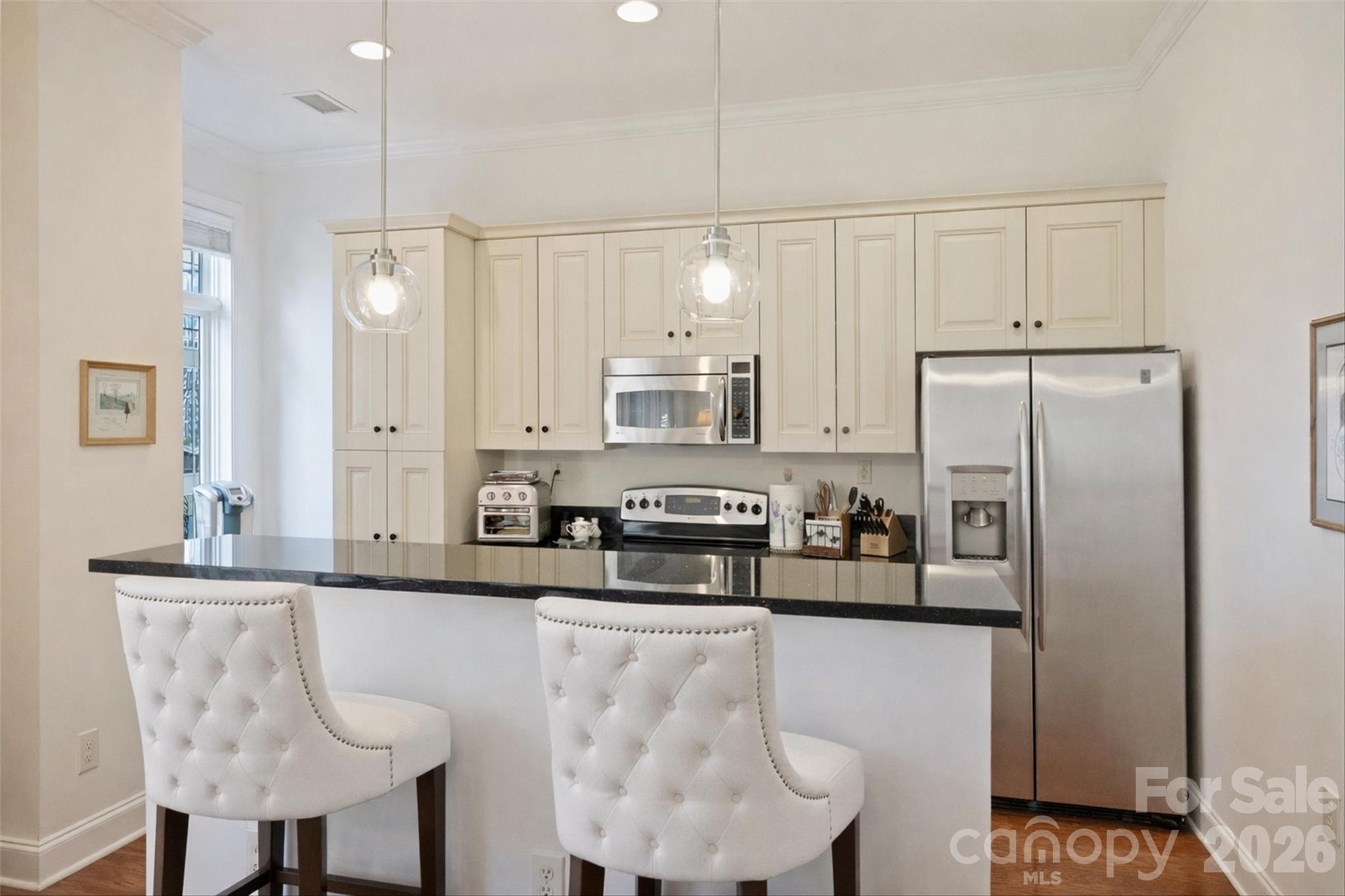 230 South Tryon Street, Unit 908 Charlotte, NC 28281 - Photo 9 of 31 a kitchen with stainless steel appliances granite countertop a sink a stove a refrigerator and cabinets