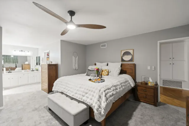 a bedroom with a large bed and a chandelier