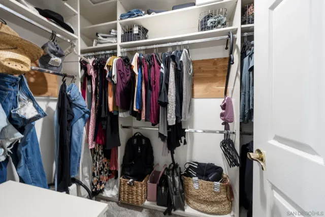 a view of walk in closet with clothes and shoes